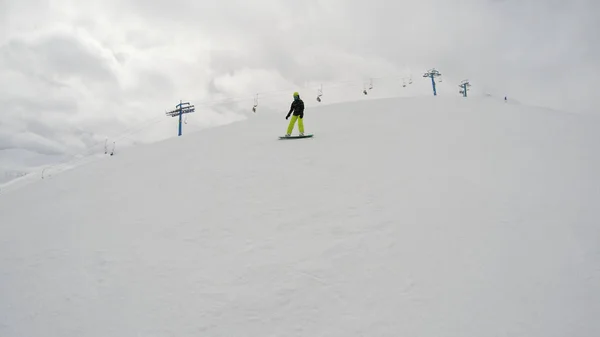 一个女孩在山上骑滑雪板 大量的雪 喀尔巴泰人滑雪夹克和裤子 — 图库照片