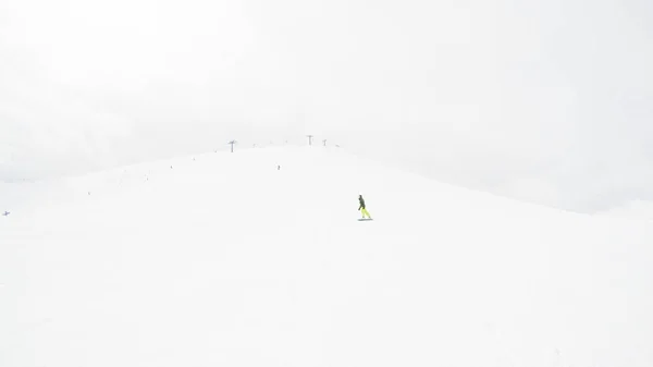 一个女孩在山上骑滑雪板 大量的雪 喀尔巴泰人滑雪夹克和裤子 — 图库照片