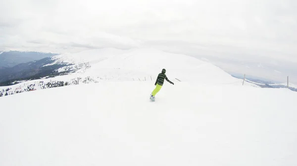 一个女孩在山上骑滑雪板 大量的雪 喀尔巴泰人滑雪夹克和裤子 — 图库照片