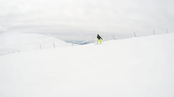 一个女孩在山上骑滑雪板 大量的雪 喀尔巴泰人滑雪夹克和裤子 — 图库照片