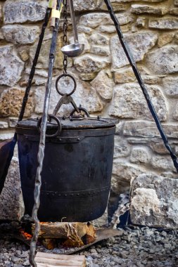 Bir dökme demir kazan geleneksel pişirme Şef. Gıda açık alev üzerinde. Birçok kişi için pişirme pan