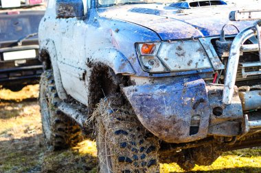Kırık tampon ve kırık far.. Kamyanets Podolsky kentinde Ukraynalı offroad yarışı. Araba üzerinde bataklık ve çamur. Büyük su birikintileri üret