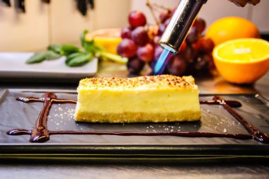 Şef bir New York cheesecake yemek pişiriyor. Mutfağı. Meyve. Deco