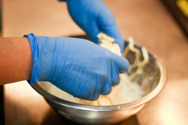 Kız şefi Eclairs için hamur yoğurma. Erik, tereyağı ve un.