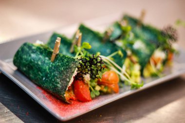 Kız şefi fesleğen peyniri ile yeşil krep rolleri hazırlanıyor