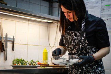 Kız şefi fesleğen peyniri ile yeşil krep rolleri hazırlanıyor