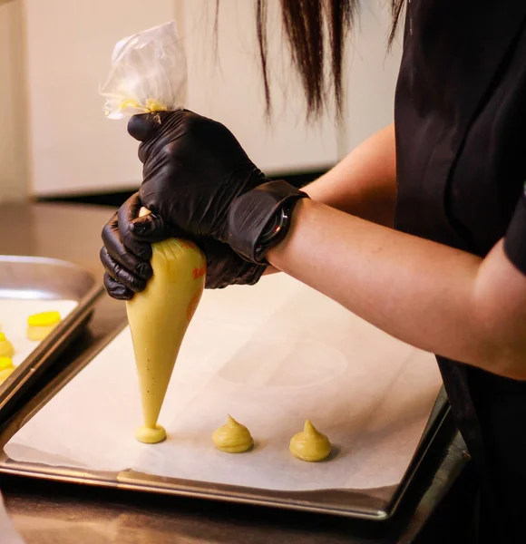 Кухарка дівчини готує еклектичний тістечко. Жовтий колір — стокове фото