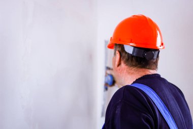 Elinde bir tükürme ile elinde turuncu bir inşaat fincan bir inşaatçı