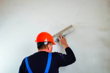 Elinde bir tükürme ile elinde turuncu bir inşaat fincan bir inşaatçı