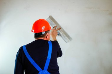 Elinde bir tükürme ile elinde turuncu bir inşaat fincan bir inşaatçı