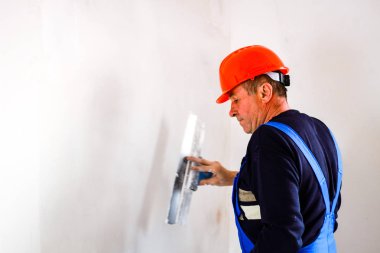 Elinde bir tükürme ile elinde turuncu bir inşaat fincan bir inşaatçı