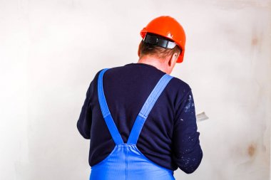 Elinde bir tükürme ile elinde turuncu bir inşaat fincan bir inşaatçı
