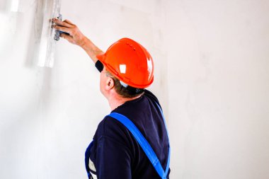 Elinde bir tükürme ile elinde turuncu bir inşaat fincan bir inşaatçı