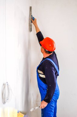 Elinde bir tükürme ile elinde turuncu bir inşaat fincan bir inşaatçı