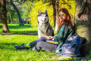 Kız parkta Husky'den bir kitap okuyor. Siyah ve beyaz yapmak
