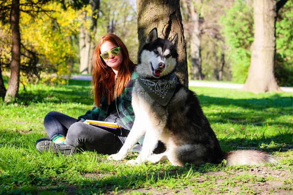 La chica lee un libro en el parque de Husky. Blanco y negro hacer — Foto de Stock