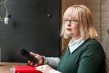 Kalın sarışın bir kadın bir kafede çalışıyor. Bir iş kadını yazıyor 