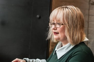 Kalın sarışın bir kadın bir kafede çalışıyor. Bir iş kadını yazıyor 