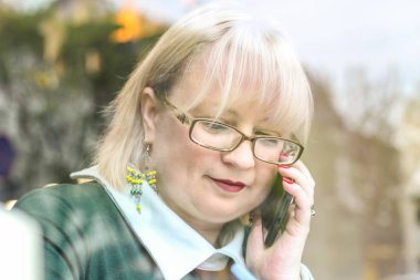 Kalın sarışın bir kadın bir kafede çalışıyor. Bir iş kadını yazıyor 