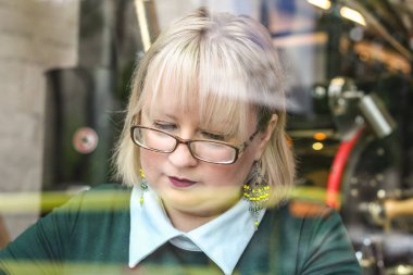 Kalın sarışın bir kadın bir kafede çalışıyor. Bir iş kadını yazıyor 