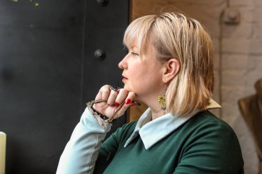 Kalın sarışın bir kadın bir kafede çalışıyor. Bir iş kadını yazıyor 