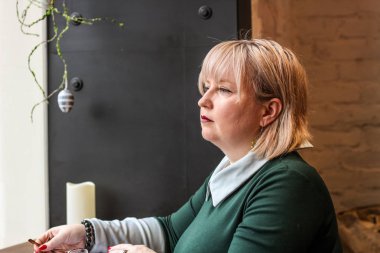 Kalın sarışın bir kadın bir kafede çalışıyor. Bir iş kadını yazıyor 