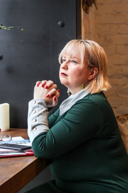 Kalın sarışın bir kadın bir kafede çalışıyor. Bir iş kadını yazıyor 