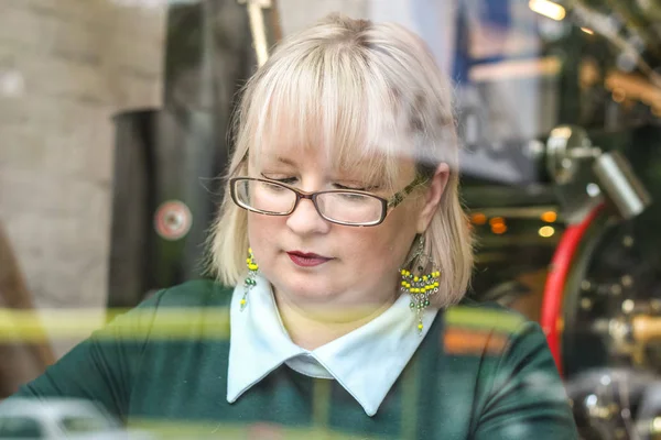 Kalın sarışın bir kadın bir kafede çalışıyor. Bir iş kadını yazıyor 