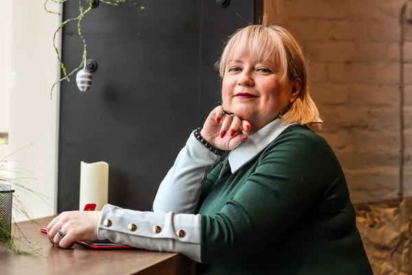 Kalın sarışın bir kadın bir kafede çalışıyor. Bir iş kadını yazıyor 