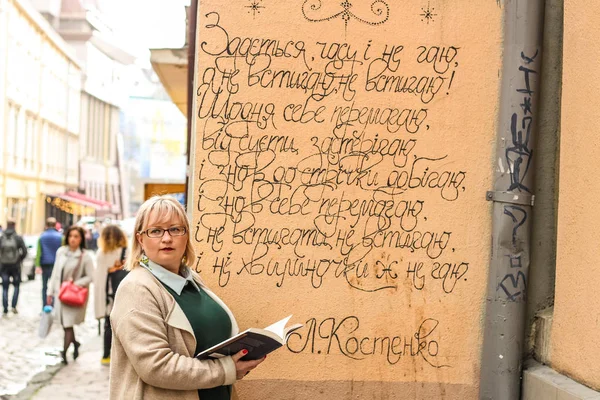 Bej bir trençkot ve kalın bir sarışın kadın portresi