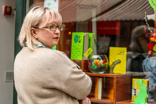 Bej bir trençkot ve kalın bir sarışın kadın portresi