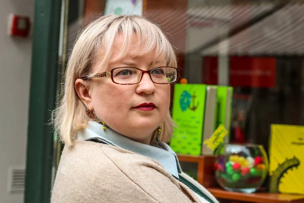 Portrait of a thick blonde woman in a trench coat of beige and a — Stock Photo, Image