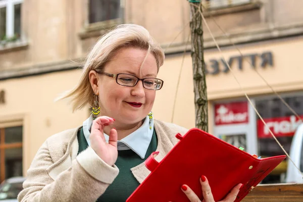 Bej bir trençkot ve kalın bir sarışın kadın portresi