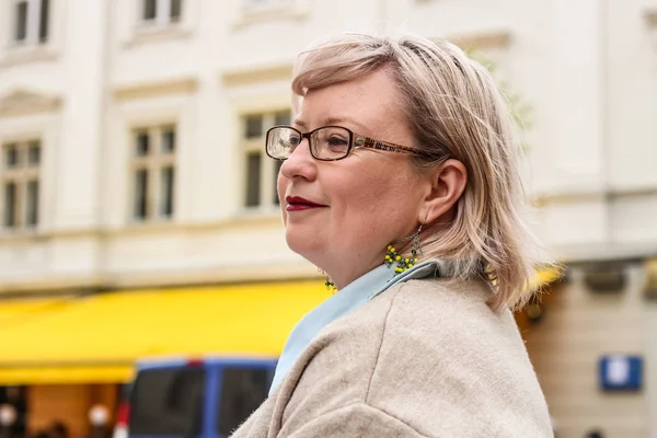 Portrait of a thick blonde woman in a trench coat of beige and a — Stock Photo, Image