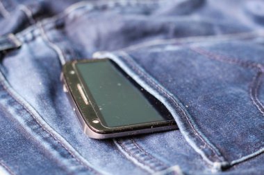 Arka cebinden çıkan beyaz ekranlı siyah telefon 