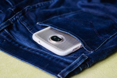 Arka cebinde beyaz bir ekranı olan beyaz bir telefon. 