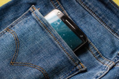 Arka cebinden çıkan beyaz ekranlı siyah telefon 