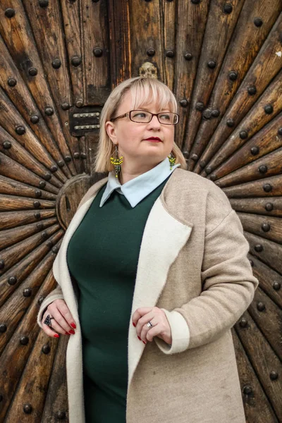 Retrato de una mujer rubia gruesa en una gabardina de color beige y un — Foto de Stock