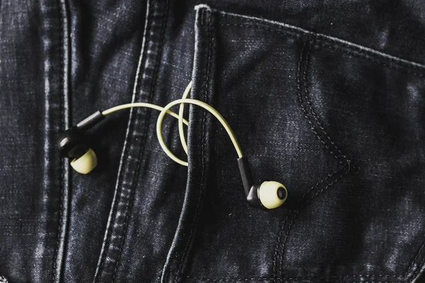 Headphones in the back pocket of jeans. Copy Space Background fo — Stock Photo, Image
