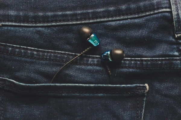 Headphones in the back pocket of jeans. Copy Space Background fo — Stock Photo, Image