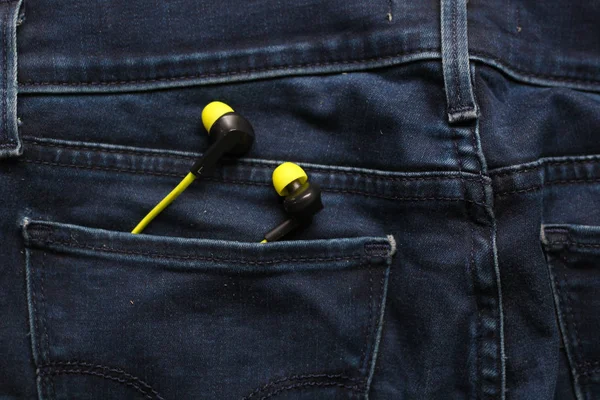 Headphones in the back pocket of jeans. Copy Space Background fo Royalty Free Stock Images