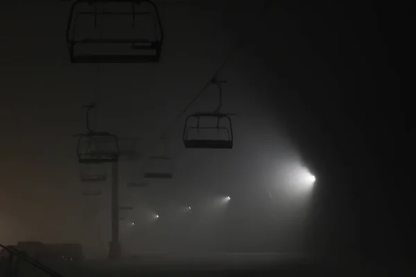 Esquí nocturno. Senderos nevados en las montañas. Iluminación de la — Foto de Stock