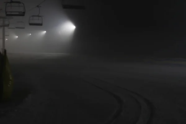 Esquí nocturno. Senderos nevados en las montañas. Iluminación de la — Foto de Stock