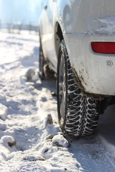 Das Auto ist weiß im Schnee. Gummi auf Rädern im Schnee. Schnee — Stockfoto