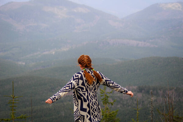 Rudy girl in the mountains in a poncho. Carpathian Mountains. Tr