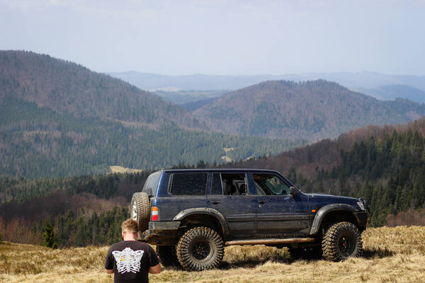 Вид на горы и машину. Внедорожник на джипе в Карпатах
