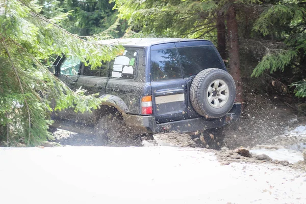 Das Auto rast durch den Wald. Offroad im Jeep in den Karpaten — Stockfoto