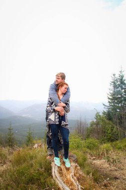 Dağlarda sevgili adam ve kız çift öpücük ve sarılmak. Tra