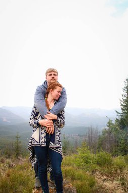 Dağlarda sevgili adam ve kız çift öpücük ve sarılmak. Tra