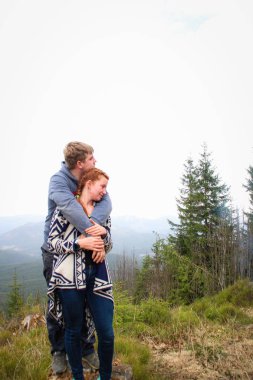 Dağlarda sevgili adam ve kız çift öpücük ve sarılmak. Tra